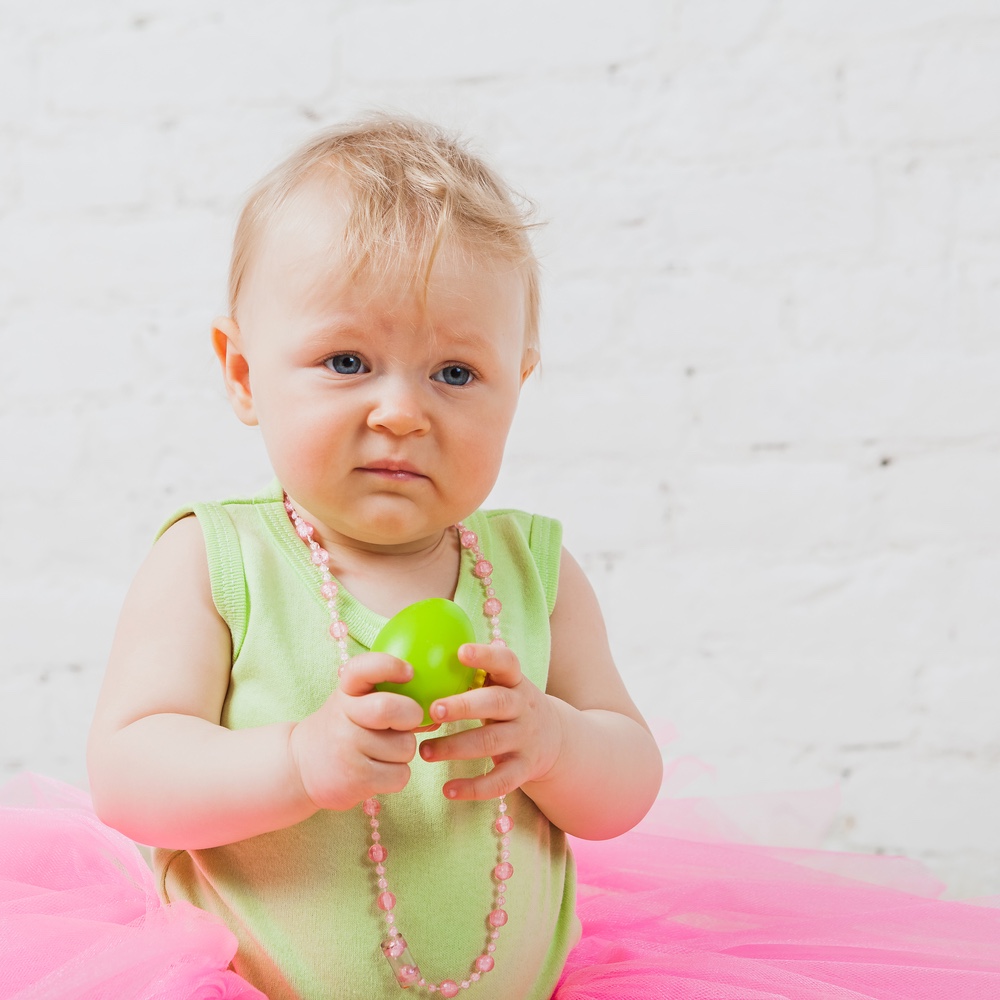 Sad baby girl holding toy