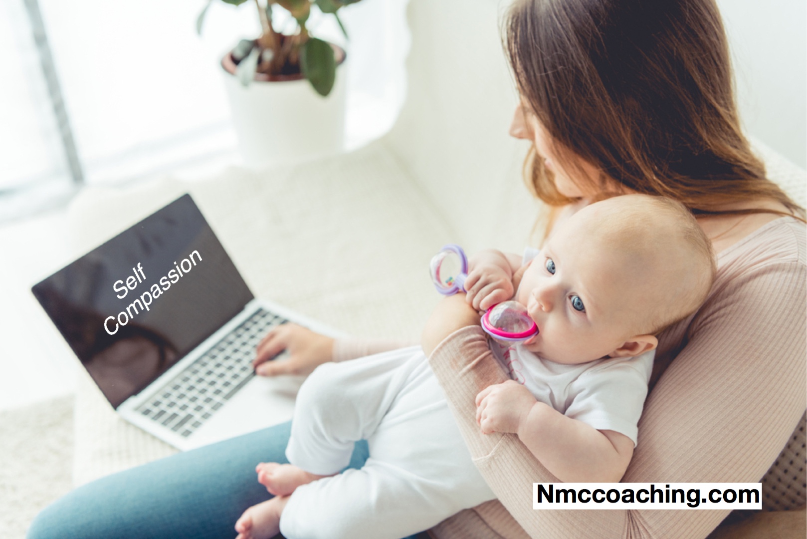 Mother holding child while working on laptop which reads, self compassion.