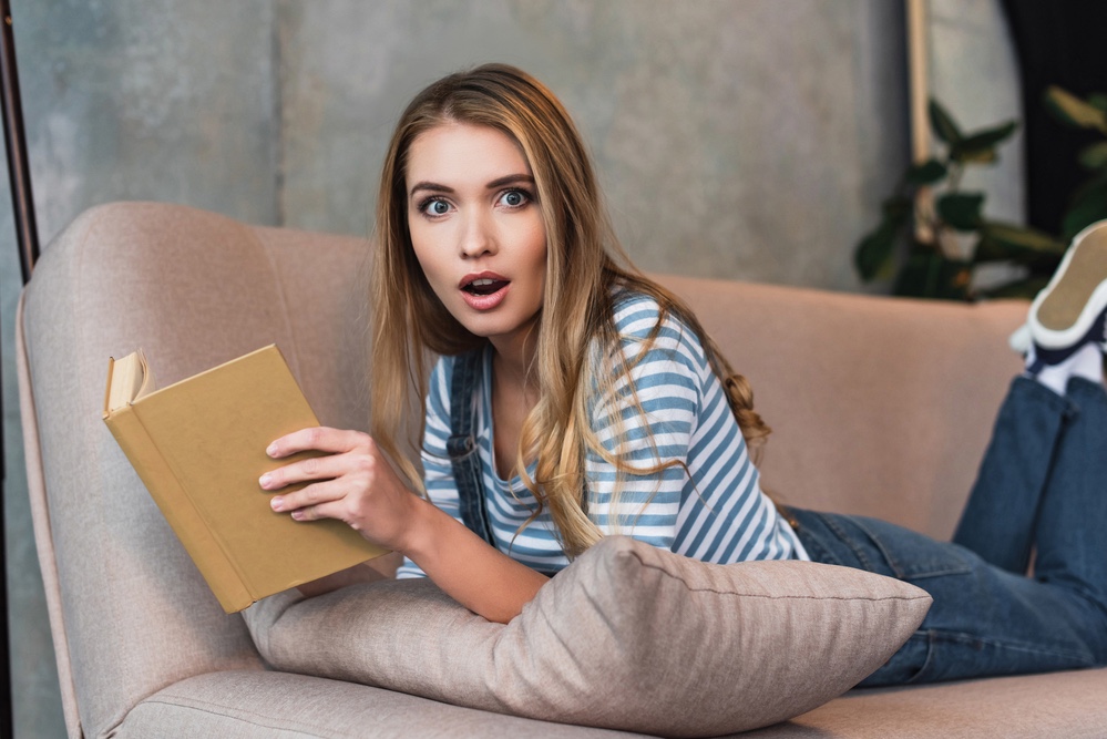 Shocked woman reading book