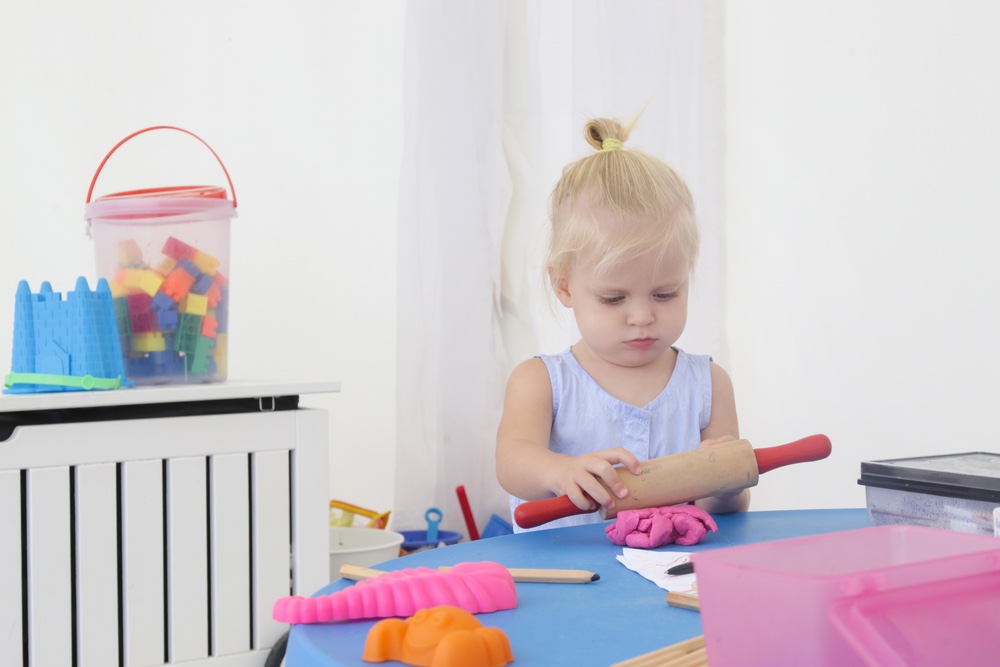 Little girl playing and learning with play-dough